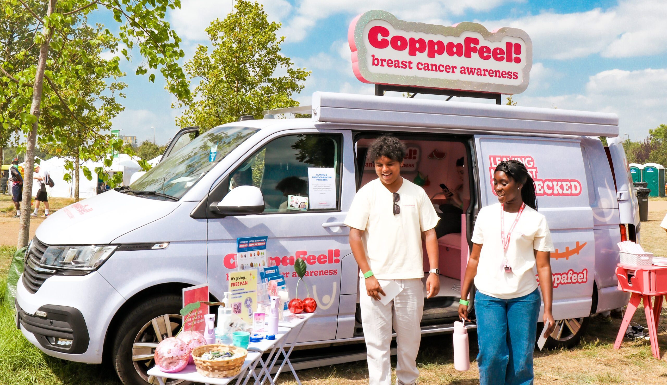Two youth network workers stand outside the CoppaFeel! van.