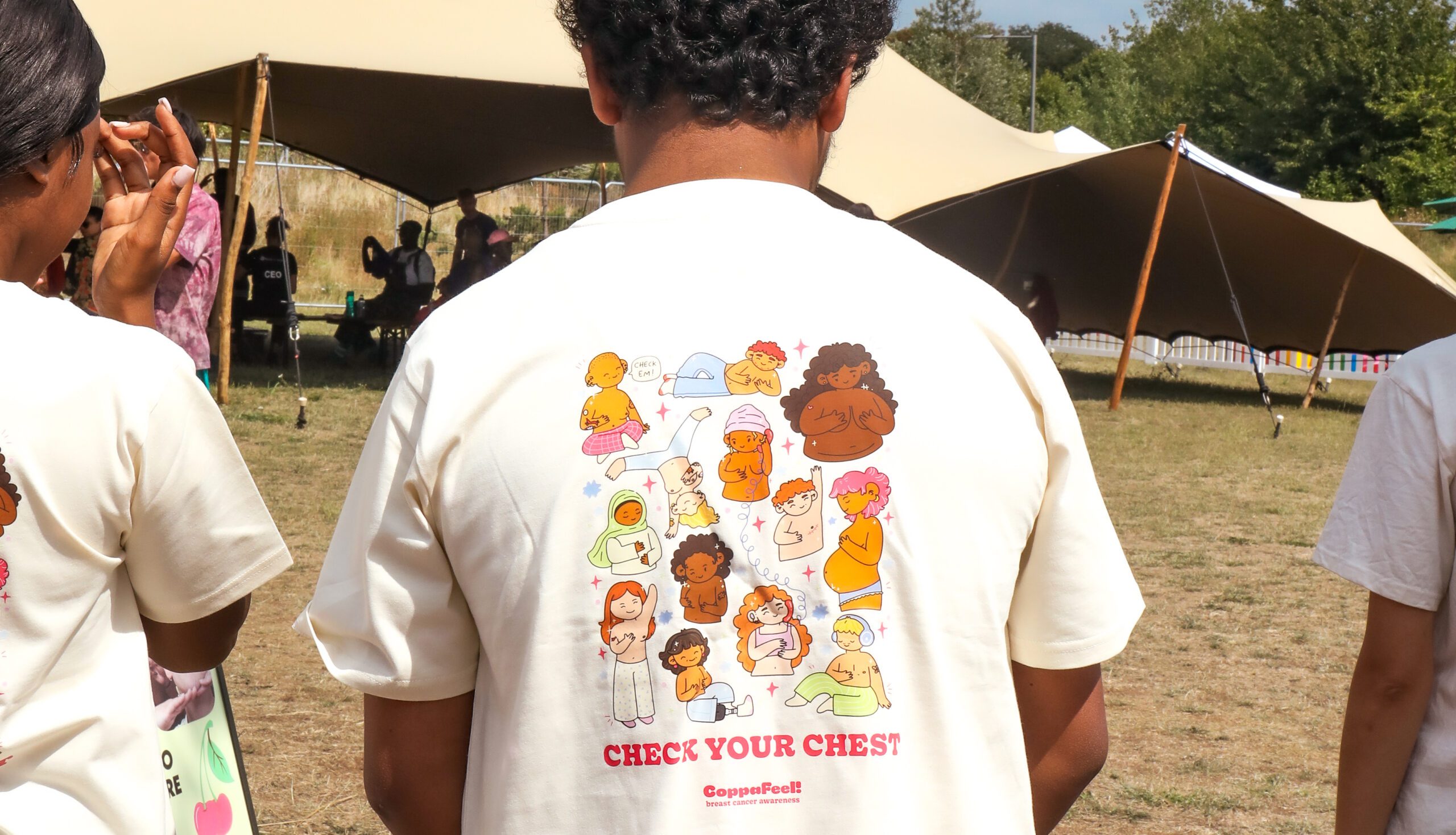 A man is stood facing away showing the back of a CoppaFeel! T-shirt.